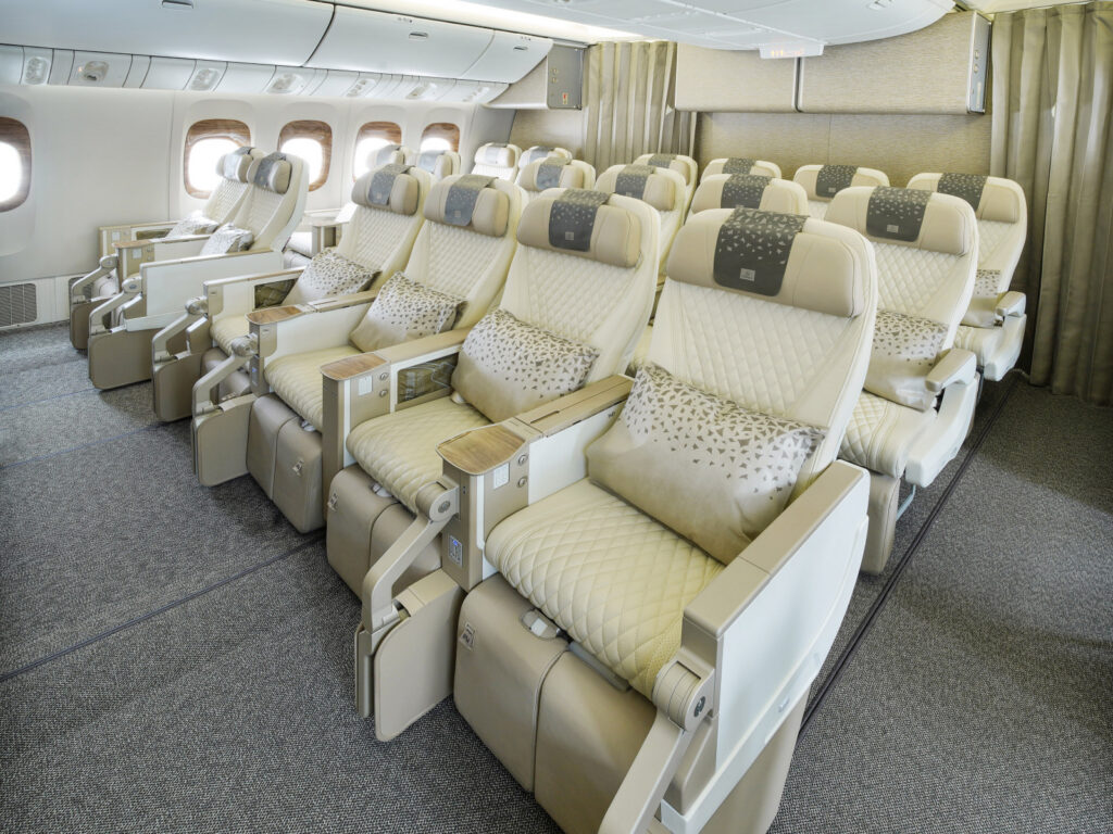 Lugares da Premium Economy da Emirates em pele creme, com almofadas